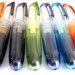 7 verschiedenfarbige Füller der Marke "Pilot Pen 1" liegen auf einer weißen Fläche
